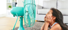 girl laying on floor in front of fan
