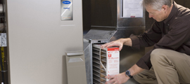 man checking filter on furnace