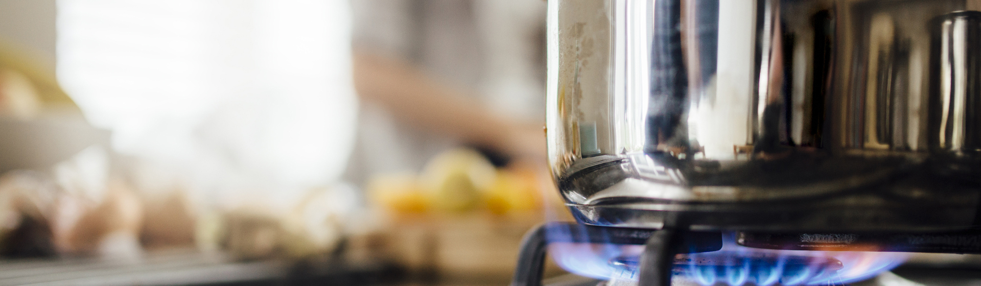 cooking pot on gas stove burner with a blue flame