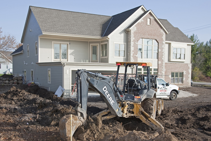 excavator truck in front of a new home construction